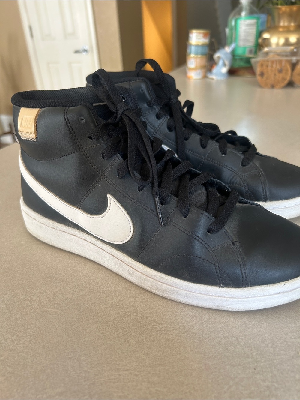 Nike women’s Black High-Top Sneakers with White Swoosh and Gold Heel Tab